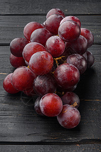 红葡萄和白葡萄 深红水果 在黑木制的桌边背景图片