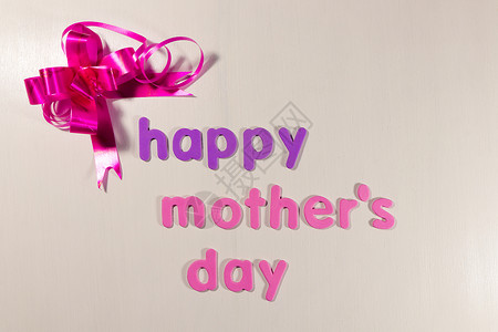 约惠母亲节母亲节快乐与粉红色的蝴蝶结丝带上惠特背景