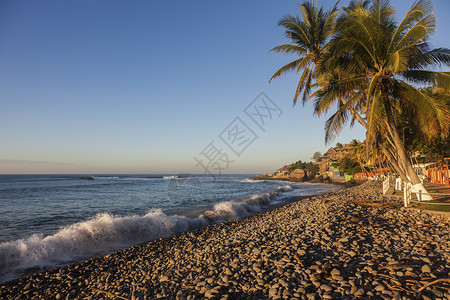 萨尔瓦多的El Tunco海滩海洋天空全景太阳报棕榈旅游村庄海浪日落街道背景图片