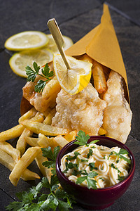 鱼薯条鳕鱼和薯条午餐海鲜面糊盘子厨房食物小吃锥体柠檬鱼片背景