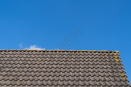 屋顶有灰色屋顶瓦片和晴朗的蓝天 阳光明媚的 da 上有一些云红色房子外国材料天空露天住宅瓷砖工艺蓝色背景图片