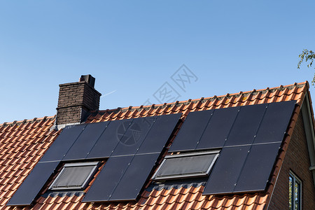 屋顶有红色屋顶瓦片和太阳能电池板 用于制造可再生能源和清澈的蓝色 sk房子瓷砖天空露天太阳能烟囱太阳能板工艺住宅材料背景图片