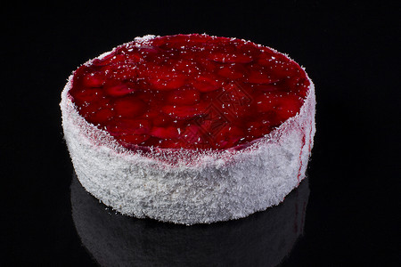 在椰子剃须上做大蛋糕 黑背景的果冻上加草莓高清图片