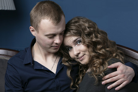 男孩和女孩坐在一起拥抱 一对年轻夫妇 恋人 一个男人喜欢一个美丽的女人背景图片