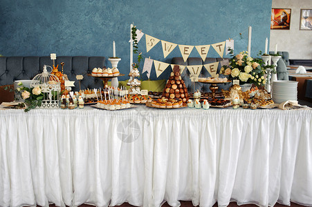 白桌布上加甜食的宴席背景图片