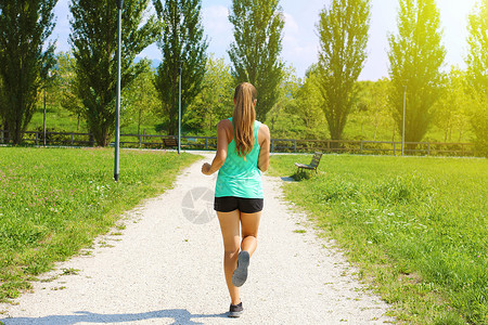 奔跑图素材跑在公园的年轻运动的妇女 在公园慢跑的健身女孩 跑在路的运动的女孩背面图赛跑者肌肉减肥拉丁女性耀斑途径训练女士阳光背景