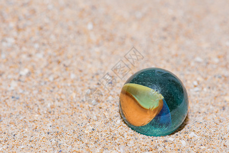 玻璃大理石 有彩色内饰 躺在沙子上石头游戏热带孩子球体海滩天气童年地球贝壳背景图片
