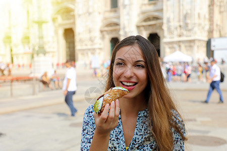 意大利米兰大教堂背景的年轻女游客食康诺利高清图片