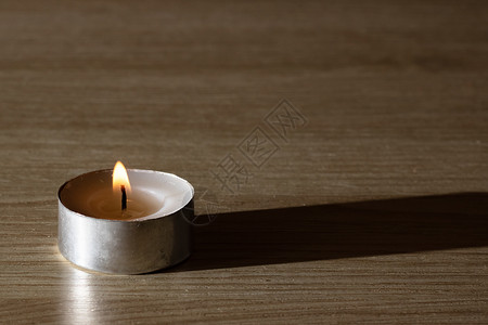 木制桌上的小蜡烛治疗木头芳香黄色疗法水平白色点燃烛光桌子背景图片