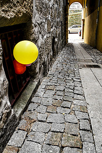 气球晾衣绳被绑在狭窄街道外墙上的多彩气球背景