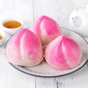 粉红中国桃子生日面包食物 在白桌背景寿涛托盘服务蛋糕茶壶木头文化盘子杯子桌子背景图片