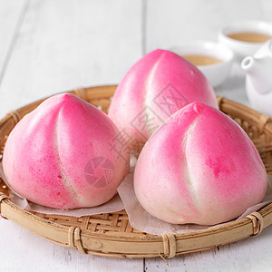 粉红中国桃子生日面包食物 在白桌背景生活美食蛋糕健康汽船盘子寿涛月球茶壶文化背景图片