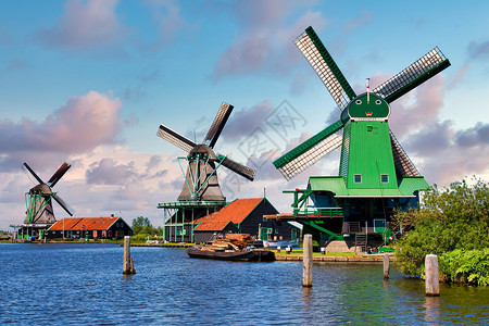 荷兰风车停在靠近荷兰阿姆斯特丹的绿色农村 有蓝天和河流水桑色蓝色旅游场地活力旅行村庄天空房子文化背景图片