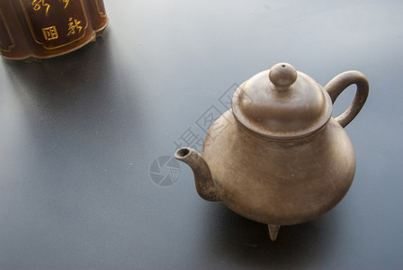 茶茶倒在对面茶壶黑色茶盒背景图片