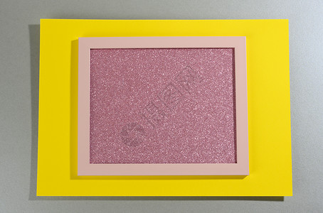 灰黄色背景下带影子的粉红色闪亮矩形框架背景图片