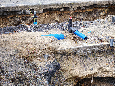 挖掘出来的在挖掘的战壕中安装蓝色钢水支管管道维修警戒线基础设施螺栓住宅排水管排水沟轮辋落水管塑料背景
