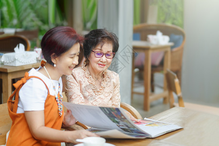 妈妈和女儿一起选择餐厅菜谱的菜单吧高清图片