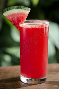 室外桌上的新鲜有机西瓜汁玻璃杯果汁花园西瓜红色晴天玻璃桌子背景图片