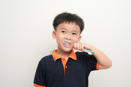 英俊的年轻男孩刷牙微笑乐趣牙科白色孩子刷子男生牙刷卫生背景图片