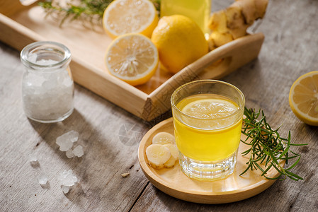 姜康Ginger Ale自制柠檬和姜有机苏打饮料 复制空间水果玻璃桌子迷迭香液体黄色背景