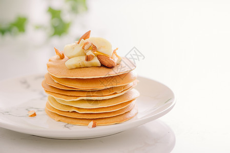 香蕉馅煎饼堆满美味的煎饼 巧克力 蜂蜜 坚果和香蕉片在石本上香蕉小麦甜点午餐早餐厨房盘子麸质饼子烘烤背景