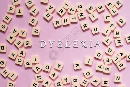 以粉红色背景为中心 DYSLEXIA 单词的字母顺序拼图块错误诊断童年学校诵读症状教育学习智力孩子背景图片