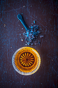 在木质表面的玻璃碗里 紧贴着生蜂蜜 还有黑色勺子中的粉状岩板 帮助人们睡好觉水晶甜点香料液体蜜蜂花蜜食物烹饪矿物治疗背景图片