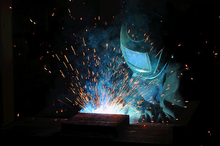 蓝色电光火花电焊机在工厂酿造钢铁活力蓝色艺术生产建造技术工作工人面具黑色背景