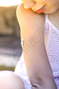 毛茸茸的毛毛虫在孩子的手上喇叭蓝色雏菊幼虫组织天空昆虫柔毛宏观动物背景图片