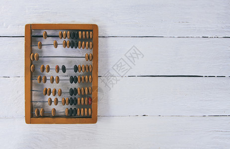 旧板表面上的复古木算盘木头教育平衡数数会计计算器数字平铺桌面珠子背景图片