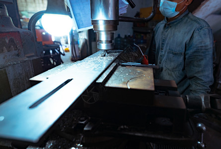 一个男人戴着外科口罩 用铣床工作 用于切割金属工件的工具 带硬质合金铣刀的立式铣床 钢铁制造行业 铣削工艺生产旋转安全面具数控男机械高清图片素材
