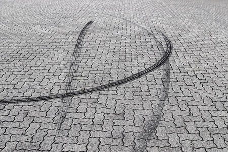 鹅卵石路上的黑色轮胎痕迹人行道铺路路面街道历史材料正方形橡皮小路水泥背景图片