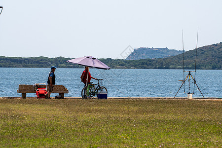 波尔图安蒂科奥尔贝特罗海滨的渔民太阳蓝色天空海滩旅行钓鱼捕鱼者渔夫海景网状背景