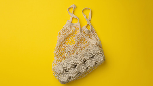 可再使用的白色纺织购物袋 蛋箱在黄色背景上 零废物 无背景图片
