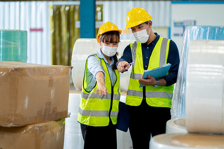 两名带卫生面具的工厂工人一起讨论在仓库工作场所管理产品 工业业务支持系统的概念帮助员工取得好成绩背景