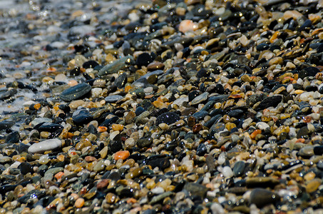 被海浪冲刷的卵石滩小而各种石头形成了海岸花园波浪支撑蓝色鹅卵石岩石砂砾地面海洋材料背景图片