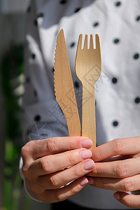 叉子o型女性手握着木质叉子和带有板块的纸杯 生态友好型可支配餐具 用于快餐 餐馆 外卖 野餐浪费工艺健康生活餐具环境回收女士杯子塑料纸板背景
