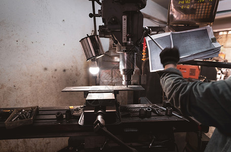 在戴着手套的工人附近工作的铣床 用于切割金属工件的工具 带硬质合金铣刀的立式铣床 钢铁制造行业 铣削工艺 金工男人高清图片素材