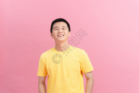 一个穿着黄色T恤的男人 站在镜头前看着摄像机学生男性折叠快乐微笑成人背景图片