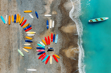 四圣兽一对漂亮的夫妇躺在法国海滩上的冲浪板旁边 用四轴飞行器拍摄 很多冲浪板异常地躺在沙滩上旅行女孩过季海浪金子海洋乐趣假期运动天线背景