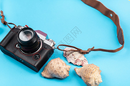 蓝色背景上的相机和贝壳 旅行的背景绳索夏令照片说谎旅游海洋海滩石头主题摄影师背景图片