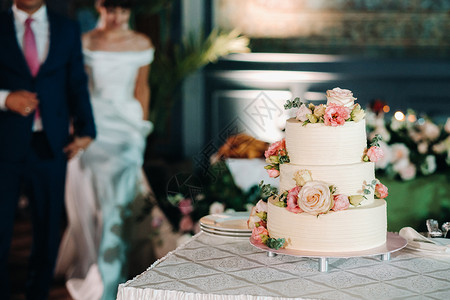 婚礼上最优美的结婚蛋糕分三层桌子花朵烟花装饰品燕尾服接待食物甜点装饰仪式背景图片