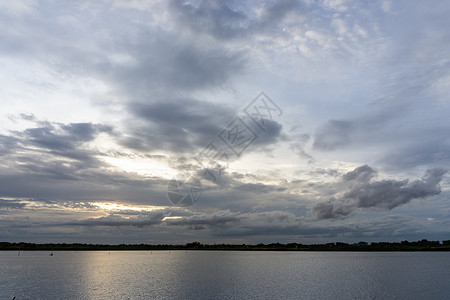 元音乌云笼罩天空 遮蔽日落时太阳的光芒背景