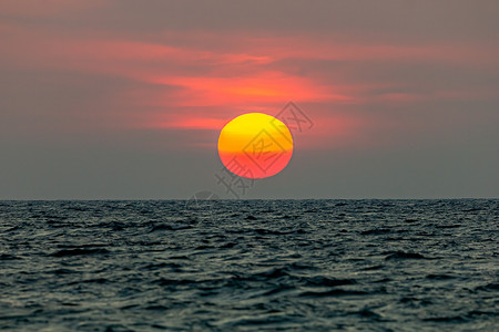 太阳落到海中 天空是橙色的 海是黑暗的风景反射日落日出阳光海浪夕阳橙子红色地平线背景图片