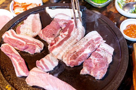 铁板生肠韩国餐厅的煎炸黑猪肉饭 新鲜美味可口科林食品烹饪用生菜制成铁板 特写 复制空间 生活方式食谱盘子炙烤文化美食猪肉芝麻叶子平底锅油背景