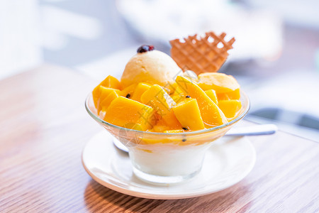 冰淇淋勺子新鲜芒果剃须冰 夏日餐厅有一勺冰淇淋和果汁酱 生活方式 台湾流行的食品木头桌子阳光橙子立方体味道果汁甜点胡扯勺子背景