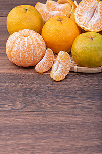 橘子熟了在黑木桌边的竹子筛子上 有新鲜 美丽的橙色橘子 季节性是中国新年月球传统水果 收尾了篮子食物甜点橙子木头摄影美食相片桌子乡村背景