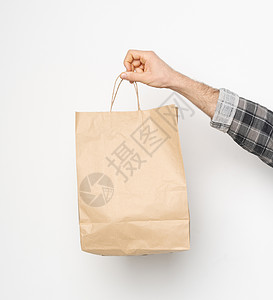 七分袖衬衣男性手用格子衬衣 折袖手持棕色纸袋 在白色背景上被孤立 交付概念 外送食品纸袋销售工艺回收生态食物包装嘲笑市场礼物环境背景