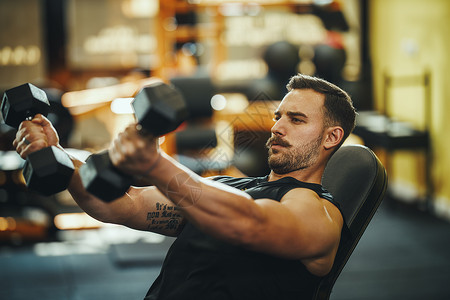 用力地推自己力量水平运动男人健身房健身肩膀成人生活方式重量背景