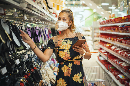 超市上戴保护面具的妇女手术预防店铺安全感冒封锁财富购物车零售防护背景图片